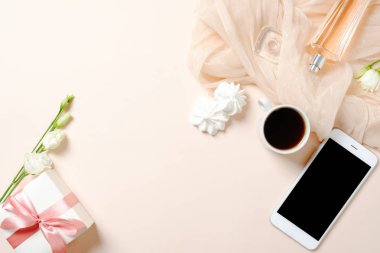 Düz yatıyordu ev ofis masası. Kahve fincanı, cep telefonu, marshmallow, hediye kutusu ve pastel pembe arka plan üzerinde eşarp ile Kadın çalışma alanı. Üst görünüm kadınsı arka plan.