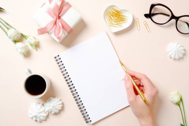 Düz yatıyordu ev ofis masası. Boş kağıt defter, kahve fincanı, hediye kutusu, marshmallow ve pembe arka plan üzerinde gül ile Kadın çalışma alanı. Metin için kopyalama alanı ile üst görünüm kadınsı arka plan.