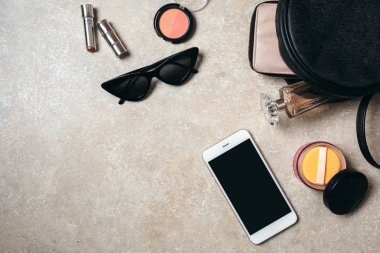 En iyi kadınsı aksesuarlarla ev ofis masası çalışma alanı. Düz güneş gözlüğü, kadın kozmetik, deri çanta, cüzdan, parfüm şişesi, akıllı telefon yatıyordu. Moda günlüğü, sosyal medya kahraman afiş.