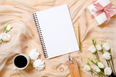 Kağıt not defteri, sabah kahve fincanı, marshmallow, parfüm, hediye kutusu ve gül çiçekleri ile üst görünümü romantik arka plan. Kadın aksesuarları ile Düz yatıyordu kadınsı masa. Moda blogger süt kavramı.