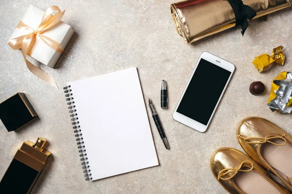 Flat lay notepad with copy space blank mockup. Top view home office desk workspace decorated with smartphone, golden feminine accessories, perfume bottle, gift box and stationery — Stock Photo, Image