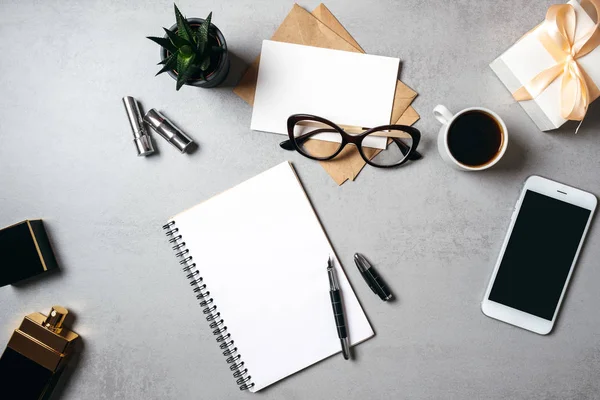 Platte lay moderne minimale huiswerk ruimte Bureau met lege Kladblok, glazen, smartphone, sappige plant, Kraft envelop, papier kaart, koffie kopje. Top View vrouwelijke Desk Business Lady blog held. — Stockfoto