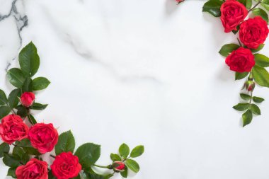 Mermer arka plan üzerinde gül tomurcukları ve yeşil yaprakları ile Çiçek çerçeve. Minimal düz yatıyordu tarzı çiçek kompozisyonu, üst görünüm, afiş kadar mock. Sevgililer günü arka plan.