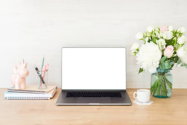 Feminine office desk table with laptop computer with blank white screen, bouquet of flowers, unicorn, stationery and supplies. Stylish woman workplace concept. Front view. — Stock Photo, Image