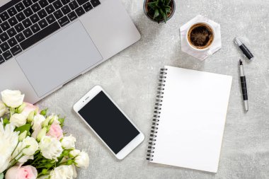 Dizüstü bilgisayar ile kadınsı çalışma alanı, boş kopya alanı mockup ekran telefon, günlük, çiçek, kahve fincanı, kalem, beton taş arka plan üzerinde sulu bitki. Düz döşeme, üst görünüm ofis masa masası