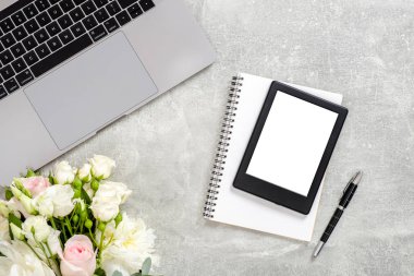 Dizüstü bilgisayar, boş kopya alanı mockup ekran tablet, çiçekler ve beton taş arka plan üzerinde malzemeleri ile Ofis masası masa. Kopya alanı ile üst görünüm, düz yatıyordu. Kadınsı çalışma alanı kavramı