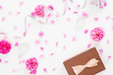 Pembe gül çiçeği tomurcukları, yaprakları, kurdele, beyaz arka plan üzerinde hediye kutusu ile Yaratıcı düğün kompozisyon. Minimal düz döşeme tarzı kompozisyon, üst görünüm. Kadın masası, moda blogger, güzellik konsepti.
