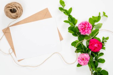 Boş kağıt kartı, zanaat zarf, beyaz arka plan üzerinde pembe gül çiçek buketi ile minimal stil kompozisyon. Düz yatıyordu, üst görünüm natürmort kavramı.