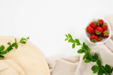 Hasır şapka, pembe bez, çilek, beyaz arka plan üzerinde böğürtlen dalı ile Home ofis masası çalışma alanı. Düz döşeme, üst görünüm.