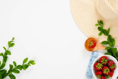 Kasede çilekli yaz sabahı kahvaltı konsepti, hasır şapka, beyaz arka planda böğürtlen dalları. Düz döşeme, üst görünüm, genel merkez.