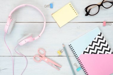 Genç kız ev ofis masası. Pastel mavi ahşap arka plan üzerinde kağıt not defteri, kırtasiye ve kadınsı aksesuarları ile Güzellik blogger çalışma alanı. Moda günlüğü kahraman afiş mockup