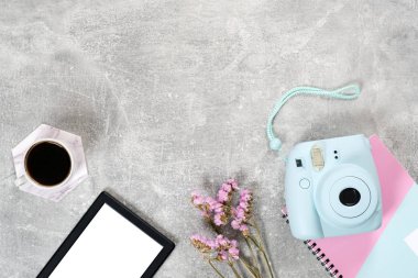 Düz yatıyordu kadınsı aksesuarlar: anında film kamera kahve fincanı, kuru çiçekler ve beton yüzeyüzerinde e kitap okuyucu. Üst görünüm güzellik blogger çalışma alanı, freelancer ev ofis masası. Moda blog kahraman.
