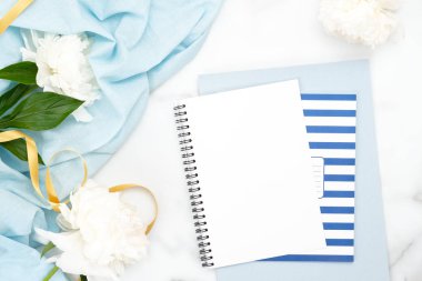 Kopya alanı, şakayık çiçekler, mermer arka plan üzerinde mavi bezler ile Kağıt not defteri. Kadınsı ev ofis masası çalışma alanı. Düz yatıyordu, üst görünüm minimal yaşam tarzı blog kahraman başlık şablonu