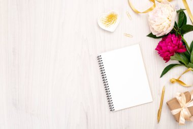 Kağıt not defteri, şakayık çiçekler, hediye kutusu ve kadınsı aksesuarları ile minimal düz yatıyordu kompozisyon. En iyi kadın ev ofis masası. Kopya alanı ile Moda blog afiş şablonu