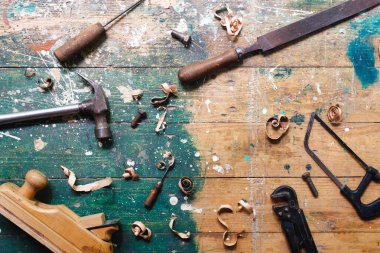 Renkli ahşap arka plan üzerinde vintage marangozluk araçları Düz yatıyordu. Marangoz farklı araçları ile üst görünüm tezgah. Diy, ahşap işçiliği, işçilik ve el işi konsepti