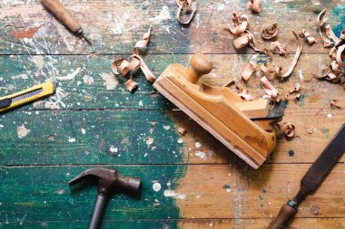 Renkli ahşap arka plan üzerinde vintage marangozluk araçları Düz yatıyordu. Marangoz farklı araçları ile üst görünüm tezgah. Diy, ahşap işçiliği, işçilik ve el işi konsepti