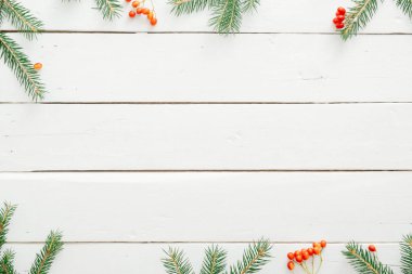 Noel minimal kompozisyon. Beyaz ahşap masa üzerinde köknar ağacı dalları yapılmış Noel çerçevesi. Noel, kış, yeni yıl konsepti. Düz döşeme, üst görünüm, kopyalama alanı