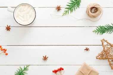 Noel kompozisyonu. Marshmallows fincan, köknar ağacı dalları, hediye kutusu, rustik ahşap beyaz arka plan üzerinde Noel dekorasyon ile sıcak çikolata. Minimal düz döşeme, üst görünüm, kopyalama alanı. Kış konsepti