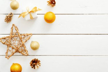 Beyaz ahşap arka plan üzerinde altın Noel süslemeleri ve süseşyaları ile Flatlay kompozisyon. Düz döşeme, üst görünüm, kopyalama alanı. Noel, Yeni Yıl, kış konsepti. Banner mockup, kartpostal şablonu
