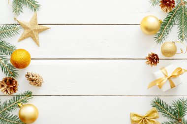Noel kompozisyonu. Flatlay altın süslemeler, topları, yıldız, beyaz ahşap arka plan üzerinde köknar ağacı dalı. Düz döşeme, üst görünüm, kopyalama alanı. Yeni yıl, Noel, kış konsepti. Xmas afiş şablonu