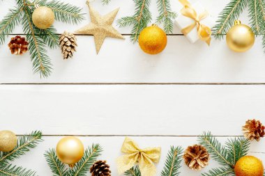 Noel kompozisyonu. Altın süslemeleri, süseşyaları, topları, yıldız, hediyeler, çam kozalağı, ahşap beyaz masa üzerinde yay ile Noel çerçeve. Noel geçmişi. Tebrik kartı şablonu, banner mockup,