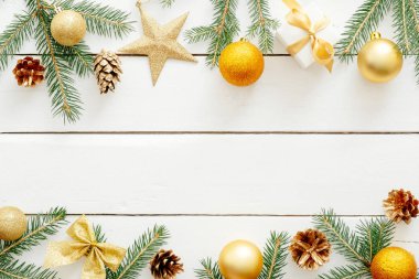 Noel kompozisyonu. Altın süslemeleri, süseşyaları, topları, yıldız, hediyeler, çam kozalağı, ahşap beyaz masa üzerinde yay ile Noel çerçeve. Noel geçmişi. Xmas Kartpostal şablonu, banner mockup