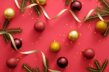 Noel veya Yeni yıl kompozisyon Noel topları, altın kurdele, kırmızı arka plan üzerinde köknar ağacı dalları yapılmış. Düz yatıyordu, üstten bak, tepede. Noel veya Yeni yıl kavramı, kartpostal şablonu