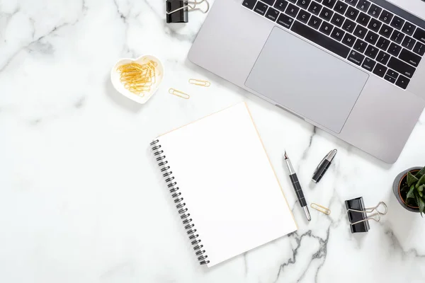 Schreibtischtisch mit Laptop, Notizblock, Schreibwaren, saftige Pflanze auf weißem Marmor. flache Lage, weiblicher Hintergrund von oben. Arbeitsplatz für Geschäftsfrau — Stockfoto