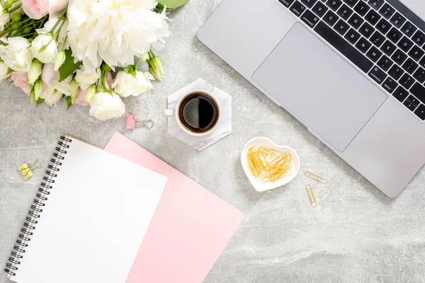 Dizüstü bilgisayar, kahve fincanı, çiçekler, günlük, beton taş arka plan üzerinde altın kırtasiye ile Kadın ofis masası masa. Düz yatıyordu, üst görünüm kadınsı çalışma alanı