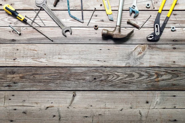 Kaba ahşap arka plan üzerinde vintage marangozluk araçları ile Düz yatıyordu kompozisyon. Marangoz farklı araçları ile üst görünüm tezgah. Ahşap işçiliği, işçilik ve el işi konsepti.