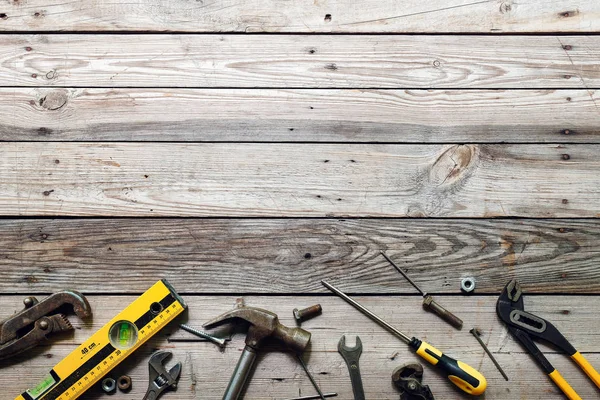 Kaba ahşap arka plan üzerinde vintage marangozluk araçları ile Düz yatıyordu kompozisyon. Marangoz farklı araçları ile üst görünüm tezgah. Ahşap işçiliği, işçilik ve el işi konsepti.