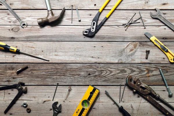 Kaba ahşap arka plan üzerinde vintage marangozluk araçları ile Düz yatıyordu kompozisyon. Marangoz farklı araçları ile üst görünüm tezgah. Ahşap işçiliği, işçilik ve el işi konsepti.