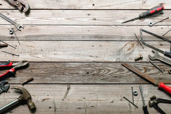 Kaba ahşap arka plan üzerinde vintage marangozluk araçları ile Düz yatıyordu kompozisyon. Marangoz farklı araçları ile üst görünüm tezgah. Ahşap işçiliği, işçilik ve el işi konsepti.