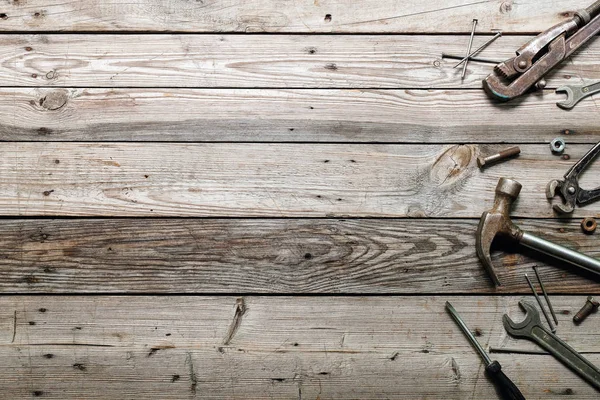 Kaba ahşap arka plan üzerinde vintage marangozluk araçları ile Düz yatıyordu kompozisyon. Marangoz farklı araçları ile üst görünüm tezgah. Ahşap işçiliği, işçilik ve el işi konsepti.
