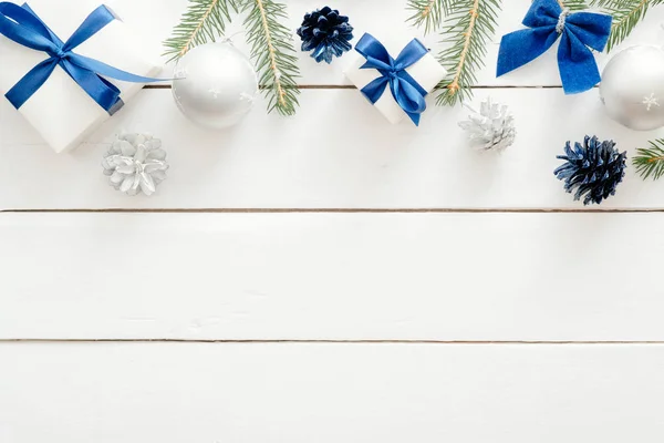 青いボール、ギフトボックス、木製の白い背景に装飾品とクリスマスフレーム。新年の休日のお祝いのバナーモックアップ。コピースペースを持つクリスマスカードテンプレート。フラットレイ、トップビュー、オーバーヘッド. — ストック写真