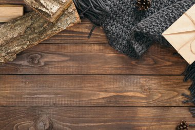 Moda örme eşarp Hygge tarzı flatlay çerçeve, zarf, ahşap arka plan üzerinde yakacak odun. Düz yatıyordu, üstten bak, tepede. Rahat sonbahar ev masası masası