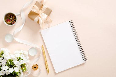 Günlük, hediye kutusu, çiçek buketi, kurdele, mumlar, pastel pembe arka plan üzerinde çay bardağı ile romantik flatlay kompozisyon. Düz döşeme, üst görünüm, kopyalama alanı. Kızlar günlüğü kavramı