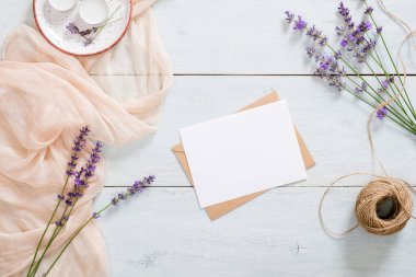 Tebrik kartı, kağıt zarf, lavanta çiçeği, pastel pembe battaniye, rustik mavi ahşap arka plan üzerinde ip. Düz döşeme, üst görünüm, kopyalama alanı. Aşk mektubu, romantizm kavramı.