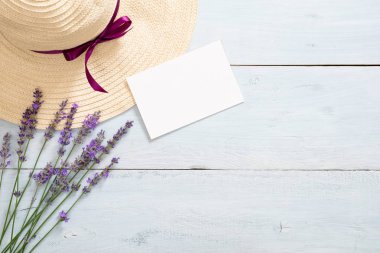 Papatya lavanta çiçekleri, hasır şapka, rustik ahşap arka plan üzerinde boş kağıt kart mockup. Minimal düz döşeme stili kompozisyon, üst görünüm, kopyalama alanı. Yaz moda konsepti.