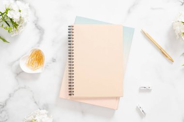 Pastel bej dizüstü bilgisayar, altın kırtasiye ve mermer arka plan üzerinde beyaz çiçekler ile ev ofis masası masa. Düz yatıyordu, üstten bak. Moda blogger çalışma alanı kavramı