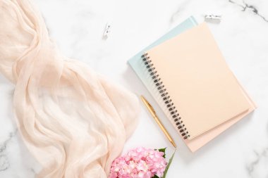 Pembe ortanca çiçek, boş kağıt defter, pastel battaniye ve mermer arka plan aksesuarları ile şık kompozisyon. Düz yatıyordu, üst görünüm moda blogger ev ofis masası.