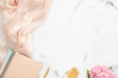 Pembe ortanca çiçek, pastel battaniye, kağıt not defteri ve mermer arka plan aksesuarları ile kadınsı çalışma alanı. Düz yatıyordu, üst görünüm, havai, Moda blogger ev ofis masası.
