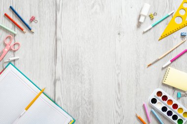 Okul defteri ve ahşap arka plan üzerinde çeşitli kırtasiye. Okul konseptine geri dönelim. Düz döşeme, üst görünüm, genel merkez.