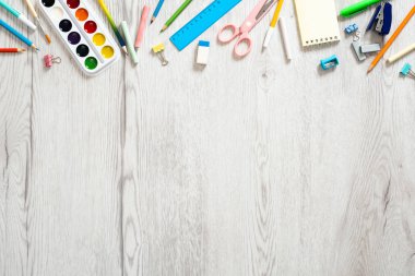 Geri okul konsepti, ahşap masa üzerinde çeşitli okul malzemeleri ve kırtasiye ile yaratıcı düzeni. Düz döşeme tasarımı, üst görünüm, genel merkez.