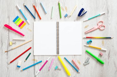 Geri okul konsepti, çeşitli okul malzemeleri ve ahşap arka plan üzerinde kopya alanı ile boş kağıt not defteri ile yaratıcı düzeni. Düz döşeme stili kompozisyon, üst görünüm, genel merkez.