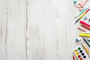 Geri okul konsepti, ahşap masa üzerinde çeşitli okul malzemeleri ve kırtasiye ile yaratıcı düzeni. Düz döşeme stili kompozisyon, üst görünüm, genel merkez.