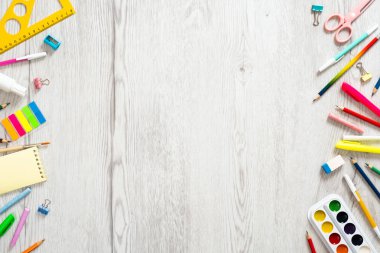 Geri okul konsepti, ahşap masa üzerinde çeşitli okul malzemeleri ile yaratıcı düzeni. Düz döşeme stili kompozisyon, üst görünüm, genel merkez.