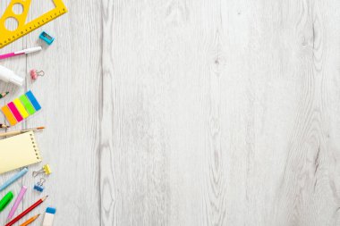 Geri okul konsepti, ahşap masa üzerinde çeşitli kırtasiye ile yaratıcı düzeni. Düz döşeme stili kompozisyon, üst görünüm, genel merkez.