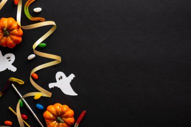 Kabaklar, hayaletler, şeker, altın kurdele ile Cadılar Bayramı karanlık arka plan. Cadılar Bayramı parti davetiye kartı mockup. Düz döşeme, üst görünüm, kopyalama alanı.