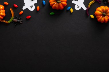 Balkabağı, hayaletler, siyah arka plan üzerinde şeker ile Halloween kompozisyon. Cadılar Bayramı parti davetiye kartı mockup. Düz döşeme, üst görünüm, kopyalama alanı.